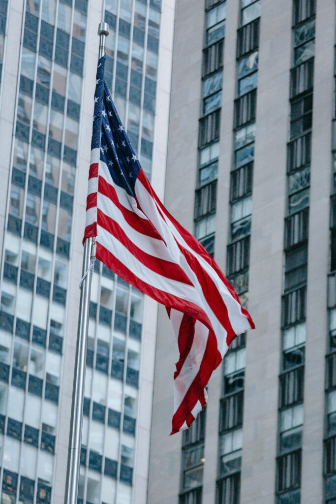 American flag flying in front of high-rise office buildings