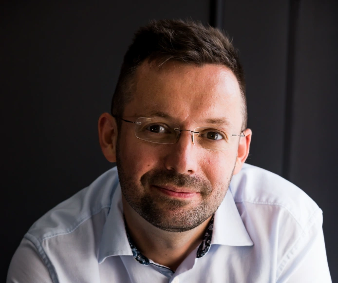Portrait of an Elevate Wealth team member wearing glasses and a white shirt