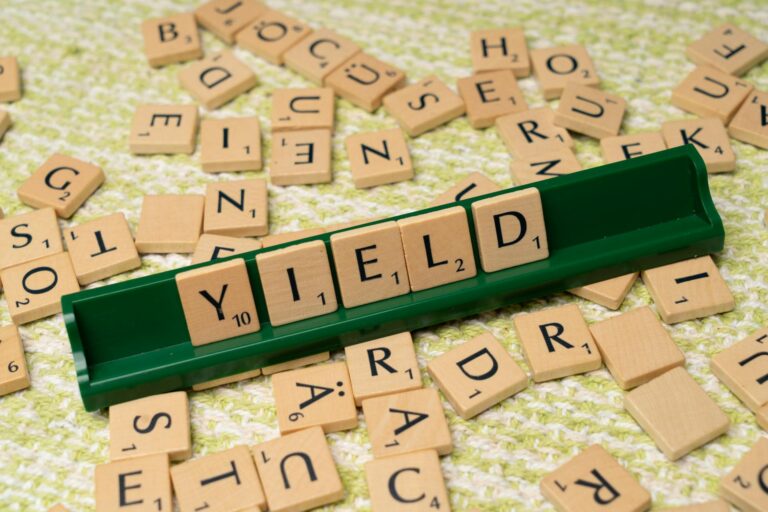 Scrabble tiles on a rack spelling 'yield', representing dividend income