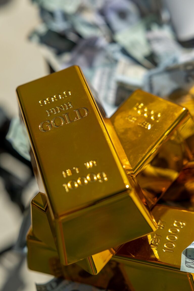 Gold bars stamped 999.9 fine gold, 1000 g, stacked on scattered banknotes