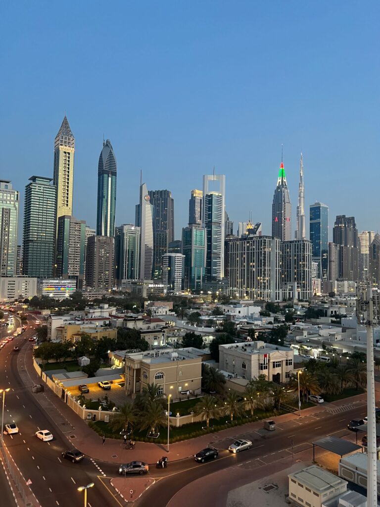 Dubai skyline at dusk with the Burj Khalifa rising behind low-rise villas